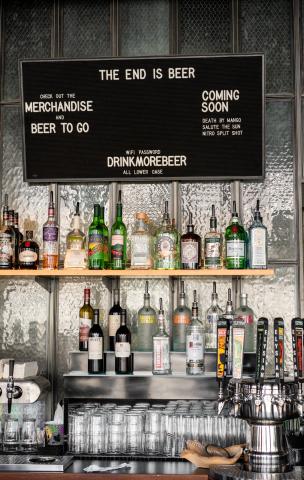 a collection of alcohol with a menu board at Elysian's Capitol Hill location